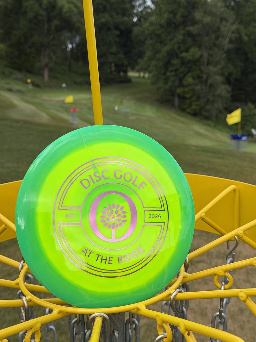 Custom Oglebay Disc Golf 'At The Ridge' stamped disc resting in a basket